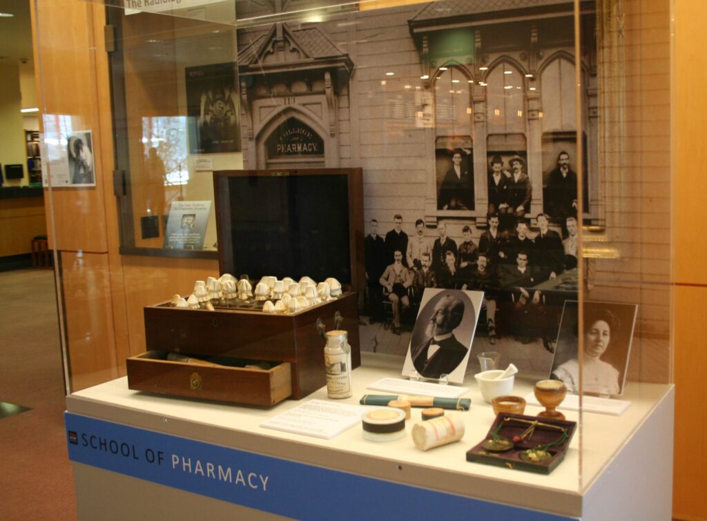 School of Pharmacy case. The exhibit includes cases dedicated to each of the four schools: School of Pharmacy, School of Nursing, School of Medicine, and School of Dentistry