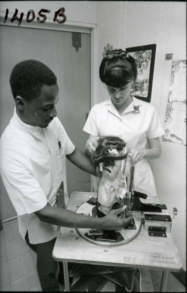 Students Debbie Modeiros and Nat Rutherford radiologic technology training school practice with doll, 1969. Photograph collection, R, Radiology Technology School.
