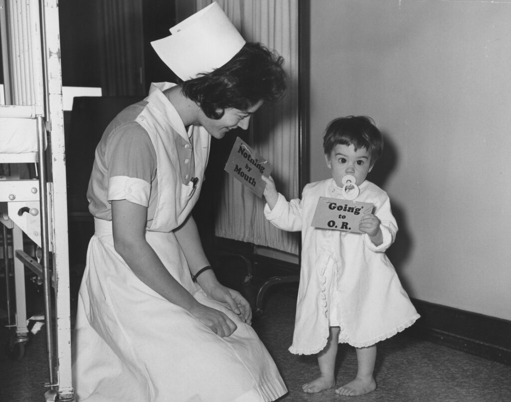 Nurse with child in St. Joseph's Hospital Pediatric Ward, circa 1940-1960. St. Joseph College of Nursing collection.