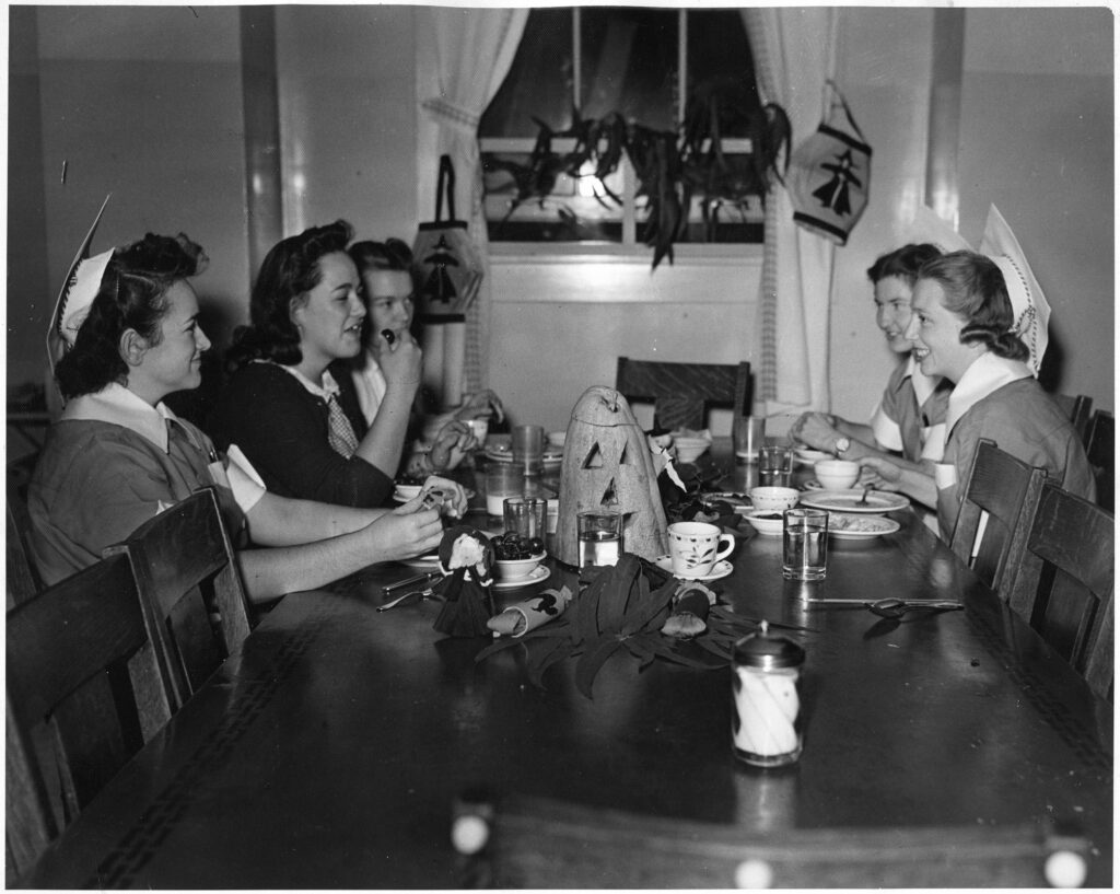 UCSF School of Nursing students at table with Halloween decorations, 1944. Photograph Collection.